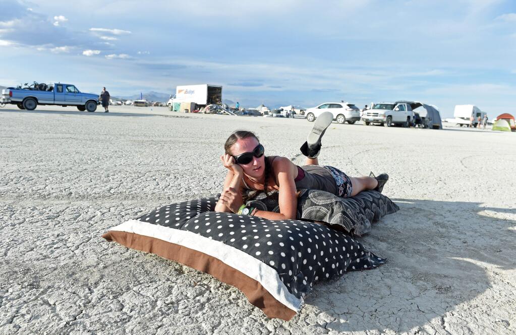 Jamie Sparks relaxes after arriving on the playa at Burning Man on Friday, Aug. 28, 2015, in the Black Rock Desert near Gerlach, Nev. Once a year, participants gather for Burning Man in Nevada's Black Rock Desert to create Black Rock City, dedicated to community, art, self-expression and self-reliance. (Andy Barron/The Reno Gazette-Journal via AP)