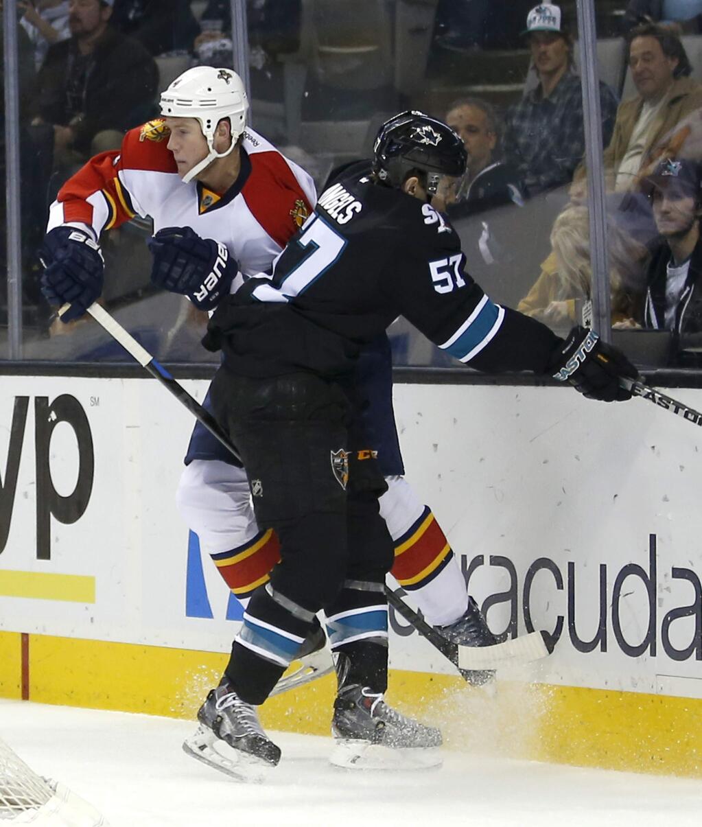 Florida Panthers defenseman Dylan Olsen (4) is checked into the boards by San Jose Sharks center Tommy Wingels (57) during the first period of an NHL hockey game Thursday, Nov. 20, 2014, in San Jose, Calif. (AP Photo/Tony Avelar)