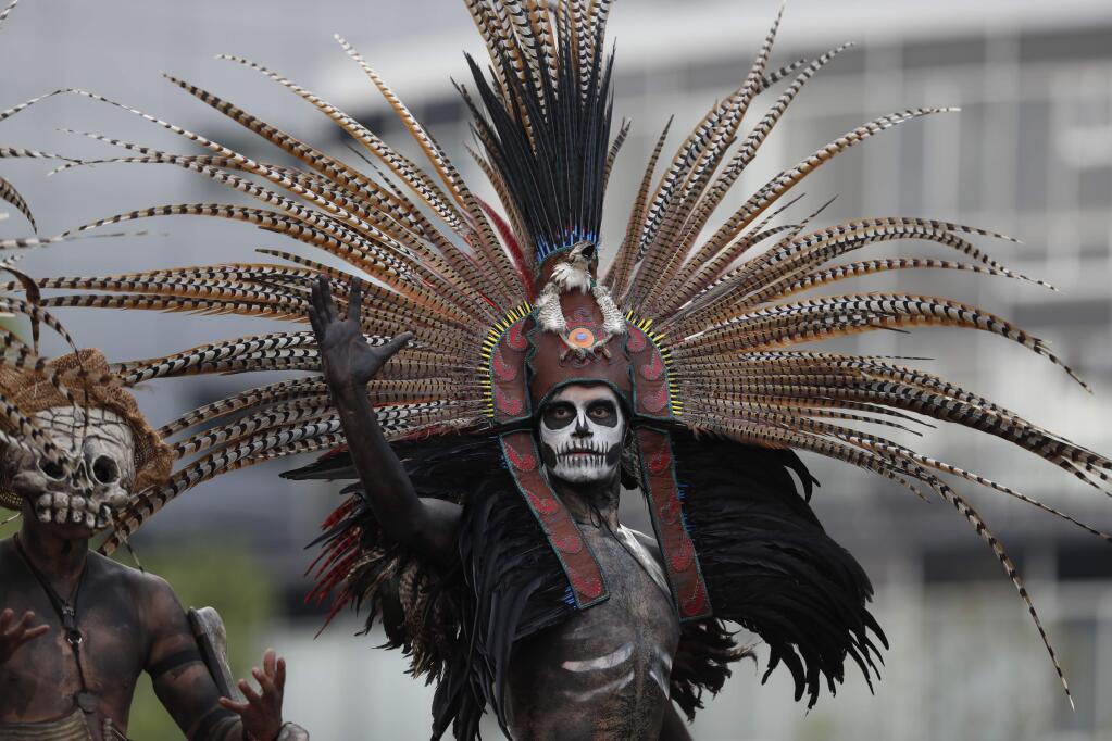 Revelers in costume participate in the Day of the Dead parade on Mexico City's main Reforma Avenue, Saturday, Oct. 28, 2017. Mexico's capital is holding its Day of the Dead parade, an idea actually born out of the imagination of a scriptwriter for the James Bond movie 'Spectre.' (AP Photo/Eduardo Verdugo)