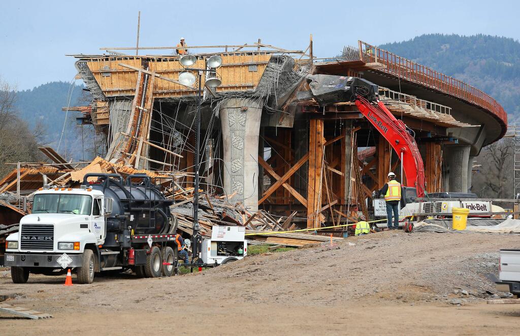 An excavator works on tearing down the collapsed section of the Highway 101 viaduct under construction in Willits on Tuesday, January 27, 2015. (Christopher Chung/ The Press Democrat)