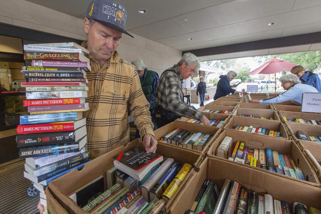 Robbi Pengelly/Index-Tribune file photoThe Friends of the Sonoma Valley Library will hold its May sale staqrting Wednesday. Here, Brian Newick picks some books from a book sale in 2017. The book sale runs through Saturday.