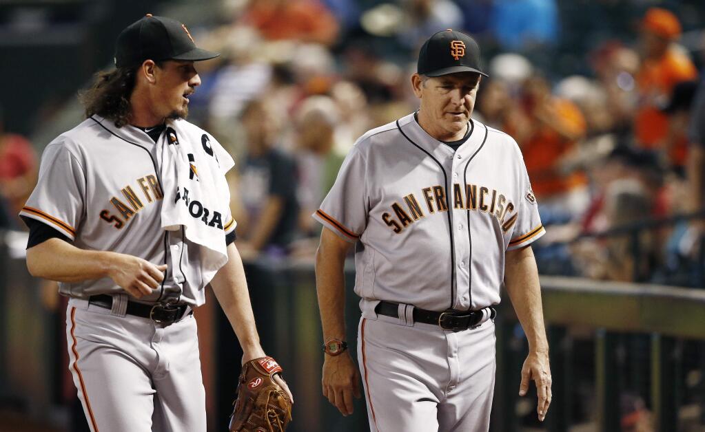 In this Sept. 27, 2017, file photo, San Francisco Giants pitcher Jeff Samardzija, left, walks with pitching coach Dave Righetti, right, after Samardzija warmed up in the bullpen before a game against the Arizona Diamondbacks in Phoenix. The Giants have reassigned Righetti from manager Bruce Bochy's field staff to special assistant to the general manager, working under Bobby Evans. (AP Photo/Ross D. Franklin, File)