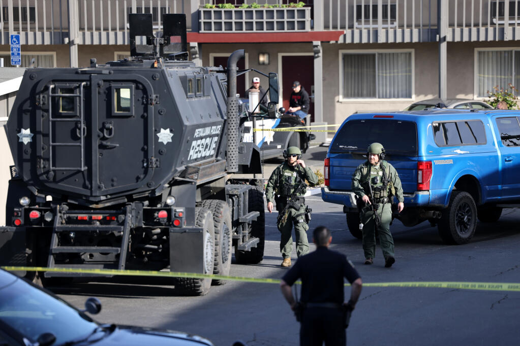 Petaluma and Santa Rosa police and SWAT team members gather in the parking lot of the Best Western Petaluma Inn during an incident with an armed suspect in Petaluma, Tuesday, March 12, 2024. (Beth Schlanker / The Press Democrat file)