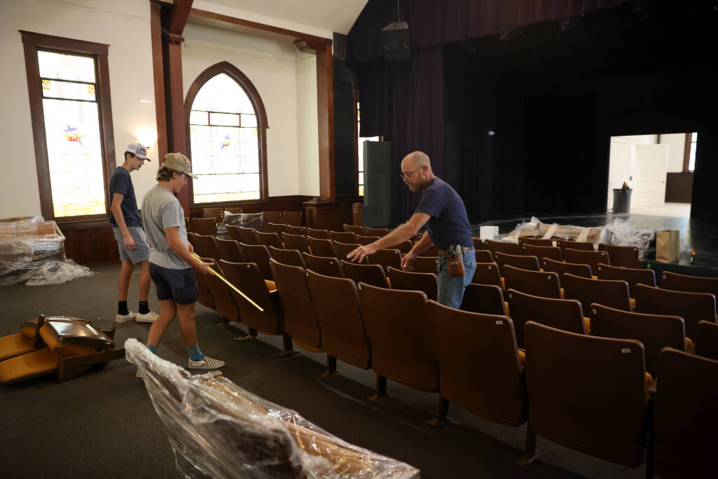 (From left) Volunteers Brody Rodrigo, 14, Brody Hansel, 14, and Brot Pierce install seats in the recently renovated Polly Klaas Community Theater in Petaluma, Calif. on Monday, August 8, 2022. (Beth Schlanker/The Press Democrat)