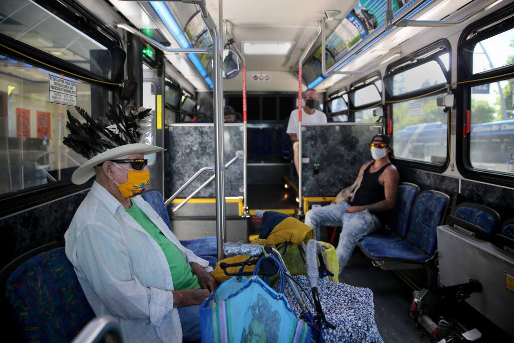 Passengers including Gonzalo Arroyo, left, sit and wait for the number 18 bus to depart the Santa Rosa Transit Mall in Santa Rosa, Calif., on Sunday, June 14, 2020. (BETH SCHLANKER/ The Press Democrat)