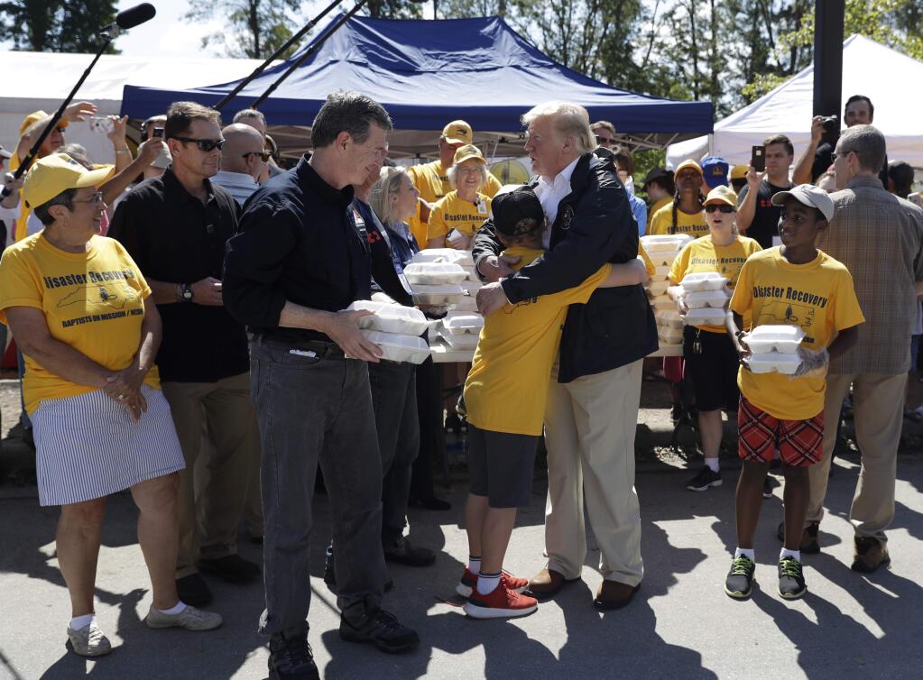 President Donald Trump and North Carolina Gov. Roy Cooper, left, greet volunteers as they prepare to hand out food at Temple Baptist Church, where food and other supplies are being distributed during Hurricane Florence recovery efforts, Wednesday, Sept. 19, 2018, in New Bern, N.C. (AP Photo/Evan Vucci)
