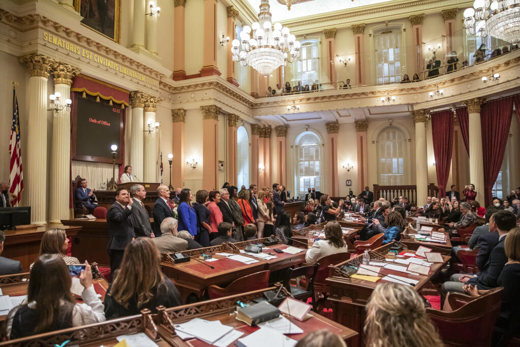 New California legislators stand to take the oath of office in the Senate chambers in the state Capitol on Dec. 5, 2022. Photo by Martin do Nascimento, CalMatters