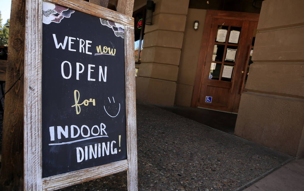 At the Beer Baron Bar and Kitchen on Fourth Street in Santa Rosa, a sign advertises they are open for indoor dining, Wednesday, April  7, 2021. (Kent Porter / The Press Democrat) 2021