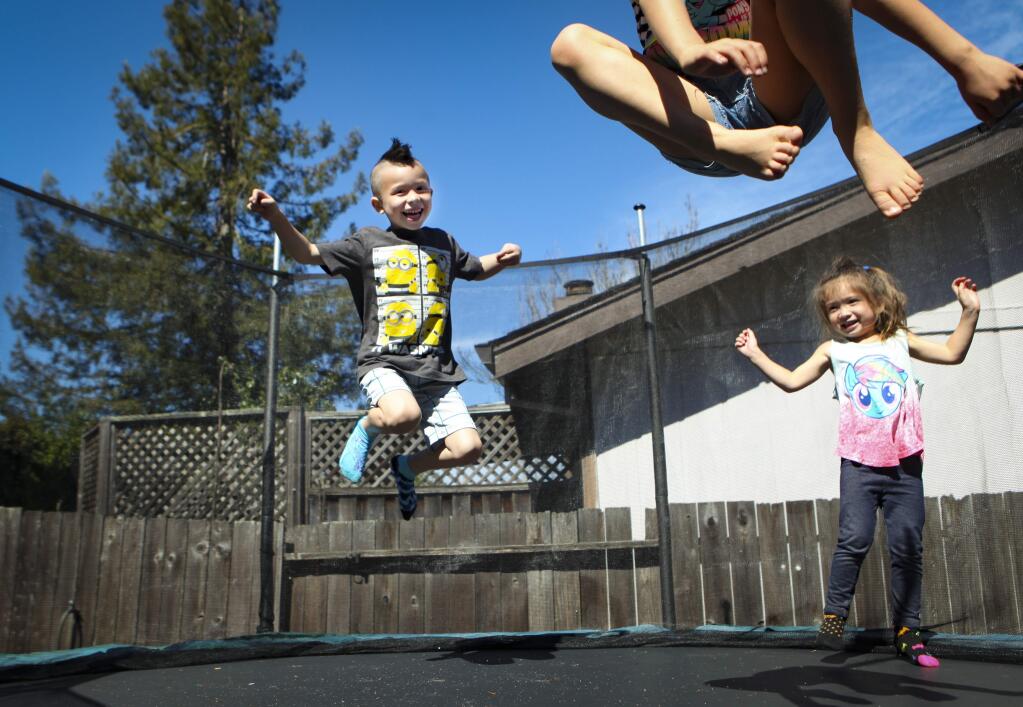 Petaluma, CA, USA._Sunday, March 31, 2019. Kawika Ho (left), 6, plays with his sisters, Ariana,3, and Ninel, 7, on the trampoline in their East Petaluma backyard. The Ho family enjoys a Sunday full of playing together at their home. When Kawika, 6, was in preschool he identified himself as transgender. His supportive parents, Reneé and Matt, began the process to help his transition. Thus, began Reneé's journey to help Kawika's elementary school gain valuable professional development training through the 'Welcoming Schools' program, certified through the Human Rights Campaign. Through her nonprofit at Loma Vista Immersion Academy, Amor Para Todos, she hopes to receive grant and donation money to help fund the school's training. It would become the first elementary school in Petaluma to get such training. The hope is to eventually get all the schools in the district properly trained to create gender inclusive and safe and welcome environments.(CRISSY PASCUAL/ARGUS-COURIER STAFF)