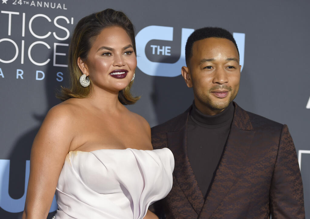 Chrissy Teigen, left, and John Legend arrive at the 24th annual Critics' Choice Awards on  Jan. 13, 2019, in Santa Monica, Calif. It's baby No. 3 for Legend and Teigen. The couple revealed they are expecting in Legend's new video for the song "Wild," which premiered Thursday and features Teigen and Legend holding her baby bump at the end of the clip. (Photo by Jordan Strauss/Invision/AP, File)