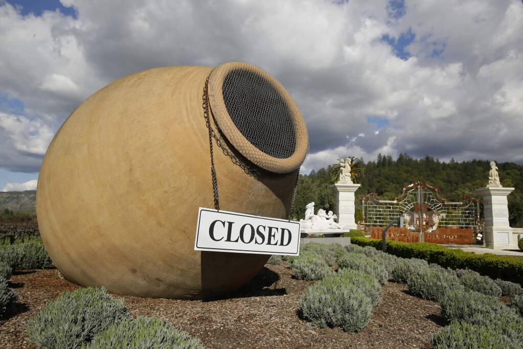 In this photo taken Thursday, March 19, 2020, a closed sign is posted outside the driveway to the Piazza Del Dotto Winery & Caves in Napa, Calif. (AP Photo/Eric Risberg)