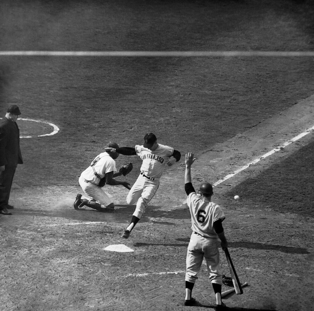 Ernie Bowman of the Giants leaps for the plate as he comes home to score for the Giants in the ninth and tie the score at 4-4, Oct. 3, 1962 in Los Angeles. Bowman scored when Orlando Cepeda hit a low liner to the outfield. At right is the next batter, catcher Ed Bailey. At left is catcher John Roseboro of the Dodgers. The Giants won 6-4. (AP Photo)
