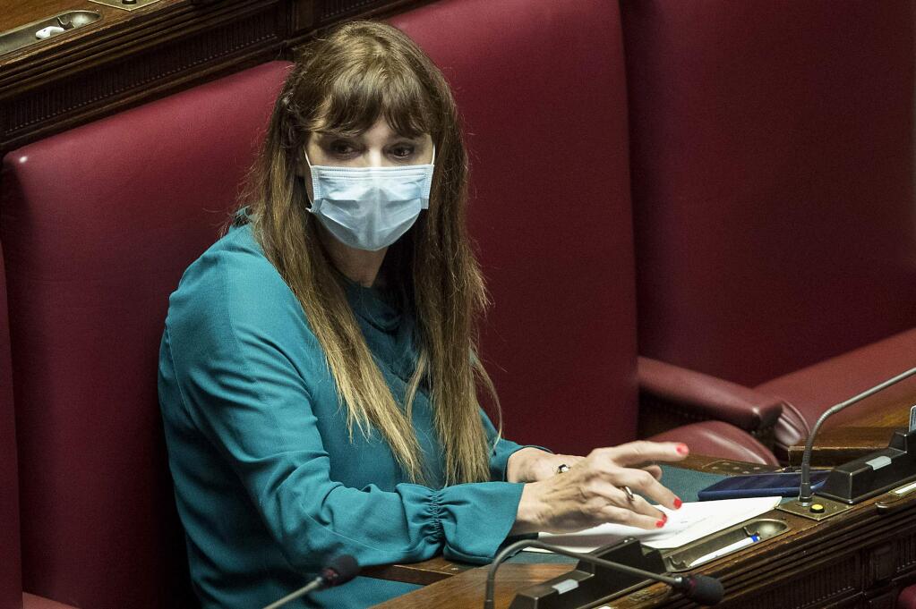 Lawmaker Maria Teresa Baldini wears a sanitary mask during a work session in the Italian lower chamber Tuesday, Feb. 25, 2020. Civil protection officials on Tuesday reported a large jump of cases in Italy, from 222 to 283. Seven people have died, all of them elderly people suffering other pathologies. (Roberto Monaldo/LaPresse via AP)