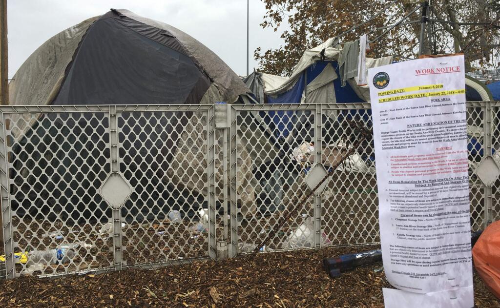 Signs warning homeless residents they'll need to move out of a two-mile long encampment are posted in Anaheim, Calif., Monday, Jan. 8, 2018. Orange County has long announced plans to clear the area of tents and tarps and officials say they will start doing so on Jan. 22, 2018. (AP Photo/Amy Taxin)