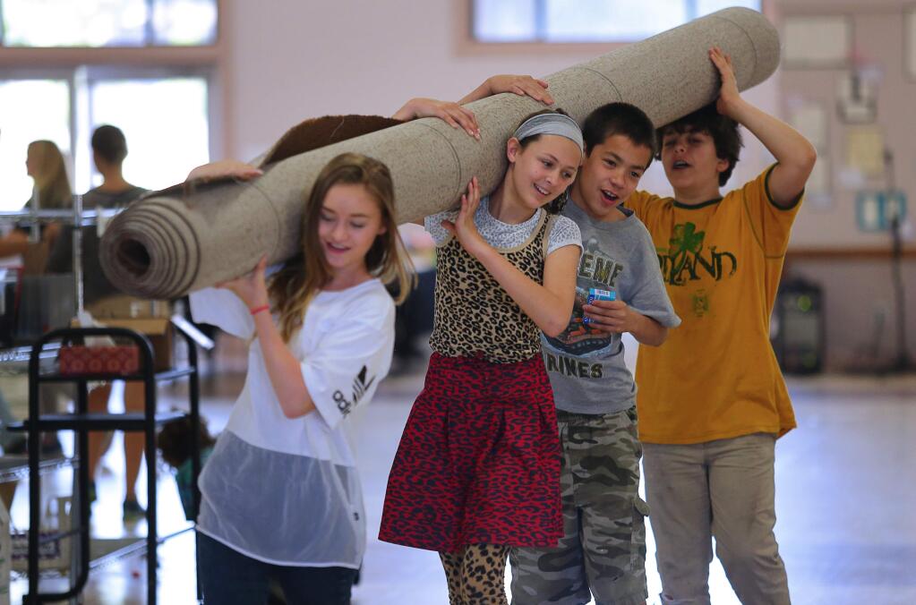 Santa Rosa Charter School students Alicia Mulder, left, Piper Paris, Kyle Collper and Owen Moosman carry a rug, while helping to pack up the school, located at the Sonoma County Fairgrounds in Santa Rosa, on Friday, May 27, 2016. (Christopher Chung/ The Press Democrat)