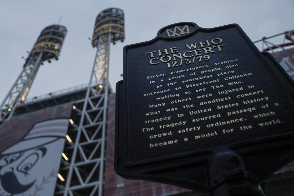 In this Wednesday, Nov. 20, 2019 photo, a memorial plaque for eleven concertgoers killed at a 1979 concert stands between Great American Ballpark and Heritage Bank Arena, in Cincinnati. Tragedy four decades ago linked the British rock band The Who to a small suburban city in Ohio. In recent years, members of the community and the band have bonded through a project to memorialize the three teens from Finneytown who were killed in a frantic stampede of people trying to get into The Who's Dec. 3, 1979, Cincinnati concert. (AP Photo/John Minchillo)