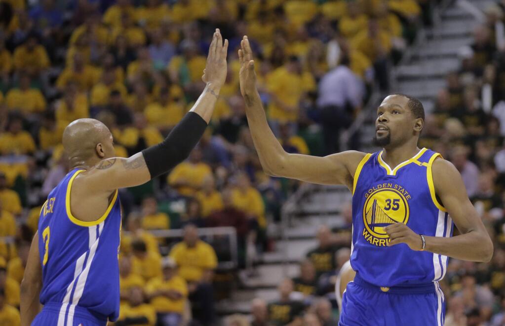 The Golden State Warriors' David West (3) high fives teammate Kevin Durant (35) after he scores against the Utah Jazz in the second half during Game 4 of their second-round playoff series Monday, May 8, 2017, in Salt Lake City. The Warriors completed a second-round sweep of the Utah Jazz with a 121-95 victory. (AP Photo/Rick Bowmer)
