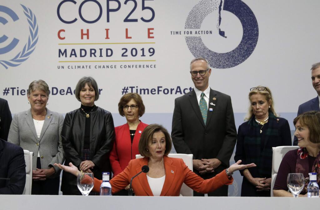 House Speaker Nancy Pelosi speaks during a press conference Monday at the COP25 climate summit in Madrid. Rep. Jared Huffman, D-San Rafael, is standing behind Pelosi. (ANDREA COMAS / Associated Press)