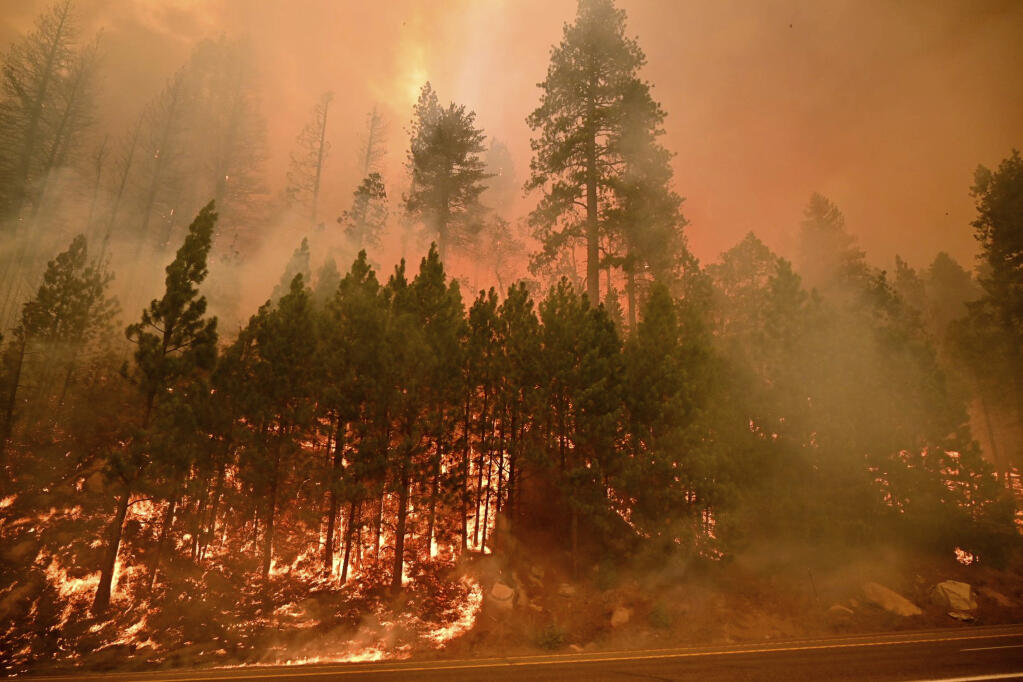 The Caldor fire burns on both sides of Highway 50 about 10 miles east of Kyburz, Calif., on Thursday, Aug. 26, 2021, as the fire pushes east prompting evacuation orders all the way to Echo Summit. (Sara Nevis/The Sacramento Bee via AP)
