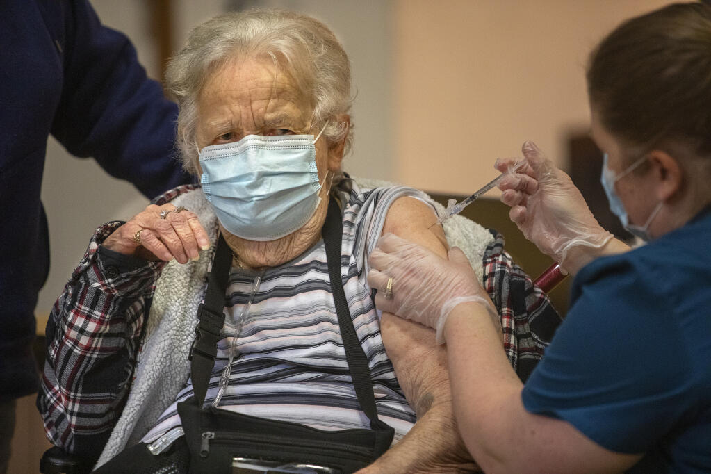 Violet McInnis, 76, of Cotati grimaces as she receives her first COVID-19 vaccine at a clinic for seniors over 75 years old at the Rohnert Park Community Center on Wednesday, Jan. 27, 2021. (John Burgess / The Press Democrat)
