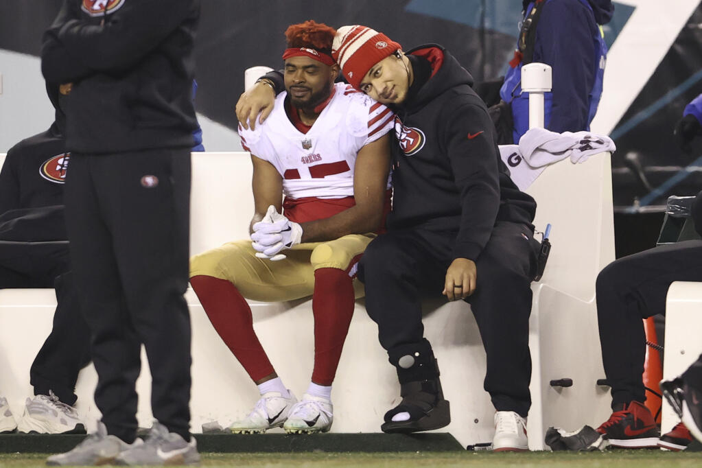 The 49ers’ Jauan Jennings, left, and Trey Lance embrace on the bench in the final minute of the Eagles’ 31-7 win in Sunday’s NFC championship game in Philadelphia (Scott Strazzante / San Francisco Chronicle)