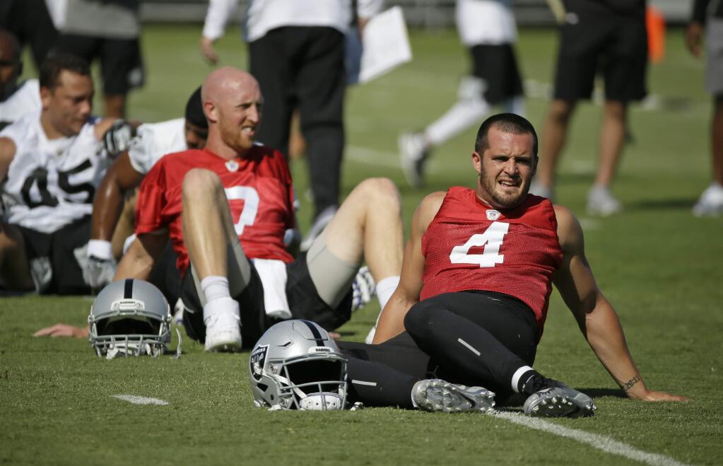 Oakland Raiders quarterbacks Derek Carr, right, and Mike Glennon stretch during training camp Saturday, July 27, 2019, in Napa. (AP Photo/Eric Risberg)