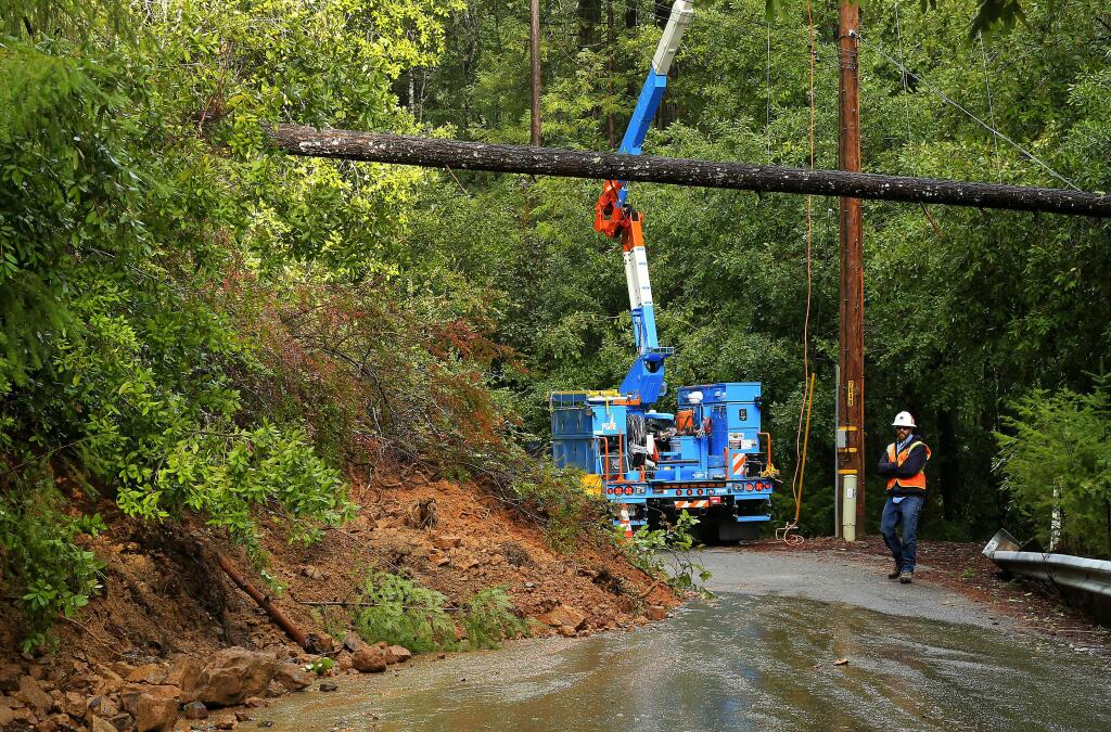 PG&E crews work to restore power to residents on Mill Creek Rd. near Healdsburg on Sunday morning, January 22, 2017. A slide on the road brought down a tree across power lines forcing the closure of the road. (John Burgess/The Press Democrat)