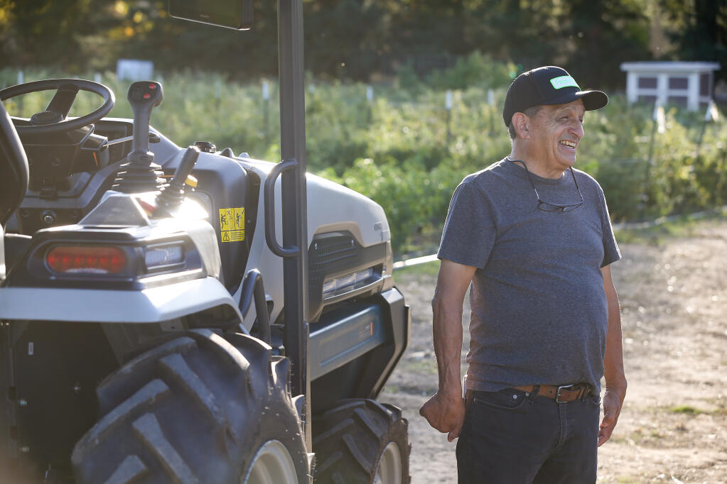 Zeke Guzman, who operates community garden JardÍn del Pueblo on his 3-acre property, smiles while talking about the new Monarch electric tractor that was donated to the garden by an anonymous donor through Sonoma Land Trust in Healdsburg, Wednesday, Nov. 8, 2023. (Christopher Chung / The Press Democrat)