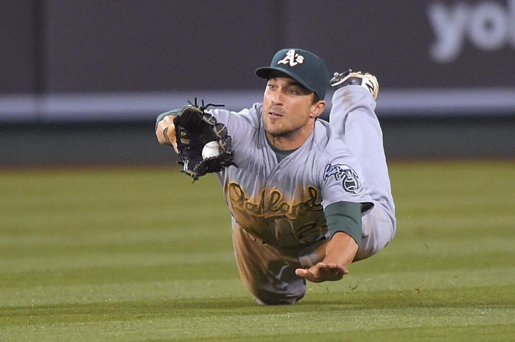 Oakland Athletics catcher Stephen Vogt makes a diving catch on a ball hit by Los Angeles Angels' David Freese during the third inning of a baseball game, Monday, April 20, 2015, in Los Angeles. (AP Photo/Mark J. Terrill)