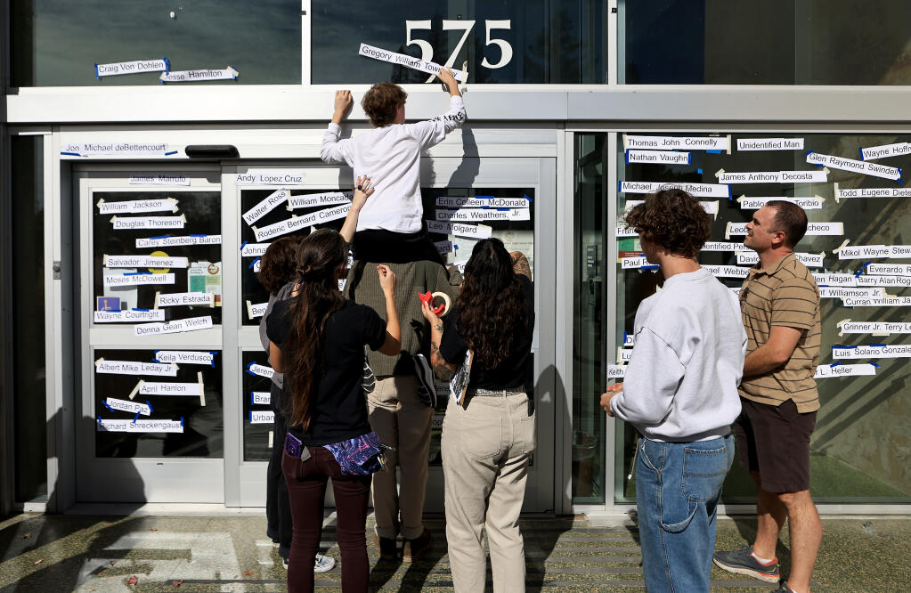 A temporary art installation is created Saturday, Oct. 22, outside the Sonoma County Administration Building in Santa Rosa that acknowledges local victims of police brutality and misconduct. (Kent Porter / The Press Democrat)