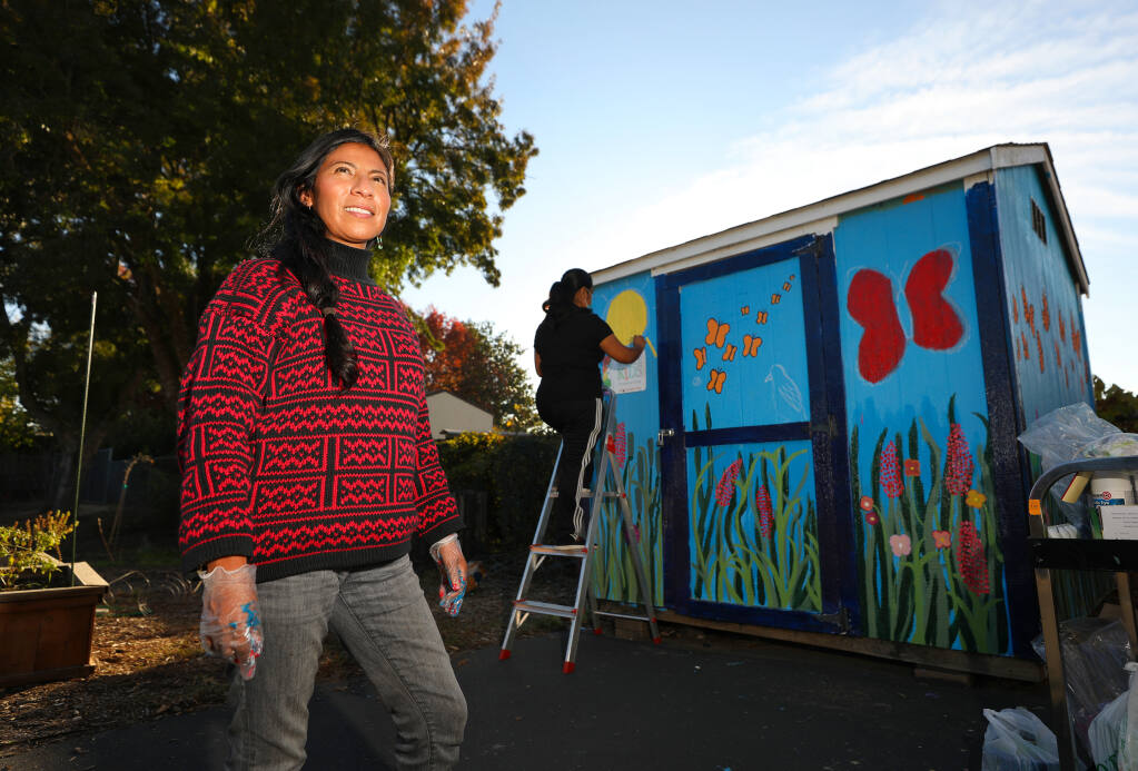 Isabel Lopez, founder and executive director of Raizes Collective, is overseeing the painting of a garden shed mural at La Plaza at Abraham Lincoln Elementary School in Santa Rosa.  (Christopher Chung / The Press Democrat)