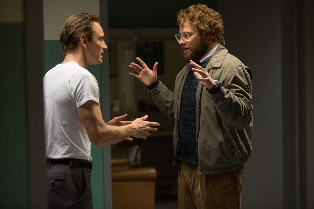 In this image released by Universal Pictures, Michael Fassbender, left, as Steve Jobs, and Seth Rogen as Steve Wozniak, appear in a scene from the film, 'Steve Jobs.' The movie releases in U.S. theaters on Friday, Oct. 9, 2015. (Francois Duhamel/Universal Pictures via AP)
