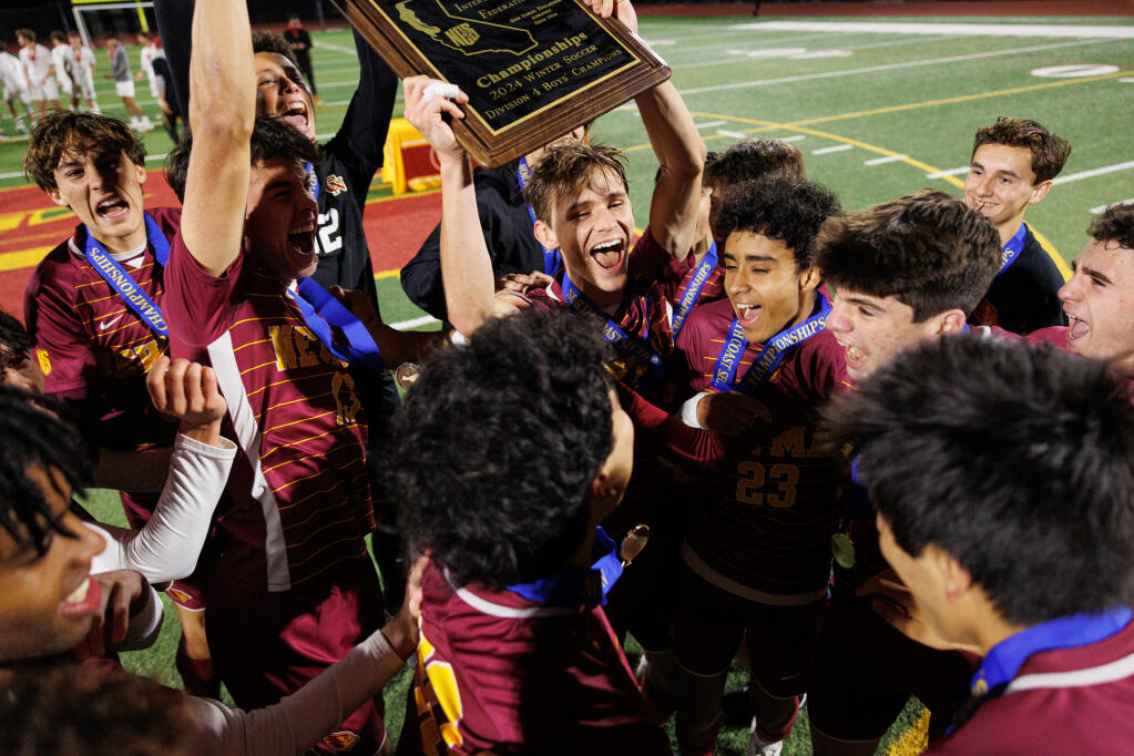 Cardinal Newman’s boys soccer team celebrates their win in the NCS championship final at Cardinal Newman in Santa Rosa on Feb. 24, 2024. (Abraham Fuentes/For The Press Democrat)