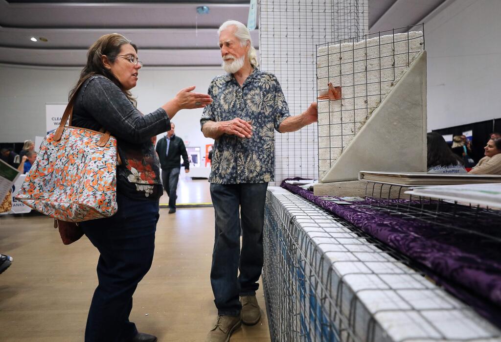 Lisa Frazee, left, talks with Blue Heron Custom Builders owner Dennis Hinrichs about the Tri D Panel, a fireproof and earthquake resistant construction material, during the Rebuild Green Expo in Santa Rosa on Friday, February 22, 2019. Frazee lost her Wikiup area home in the Tubbs fire and is exploring various materials for rebuilding in the geohazard zone.(Christopher Chung/ The Press Democrat)