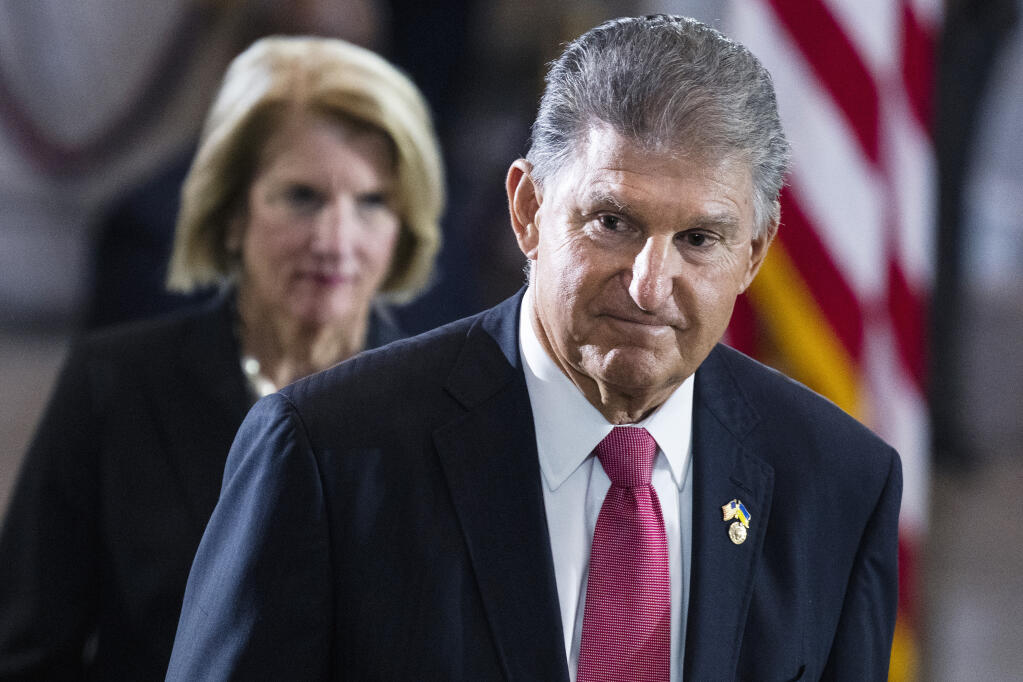 Sen. Joe Manchin, D-W.Va., and Sen. Shelley Moore Capito, R-W.Va., pay their respects as the flag-draped casket bearing the remains of Hershel W. "Woody" Williams, lies in honor in the U.S. Capitol, Thursday, July 14, 2022 in Washington.  (Tom Williams/Pool photo via AP)