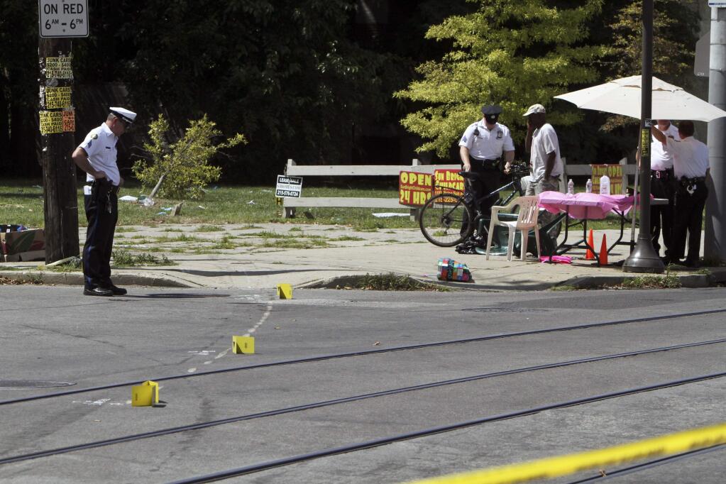 Investigators gather at the scene of a fatal accident in North Philadelphia, Friday July 25, 2014. (AP Photo/ Joseph Kaczmarek)