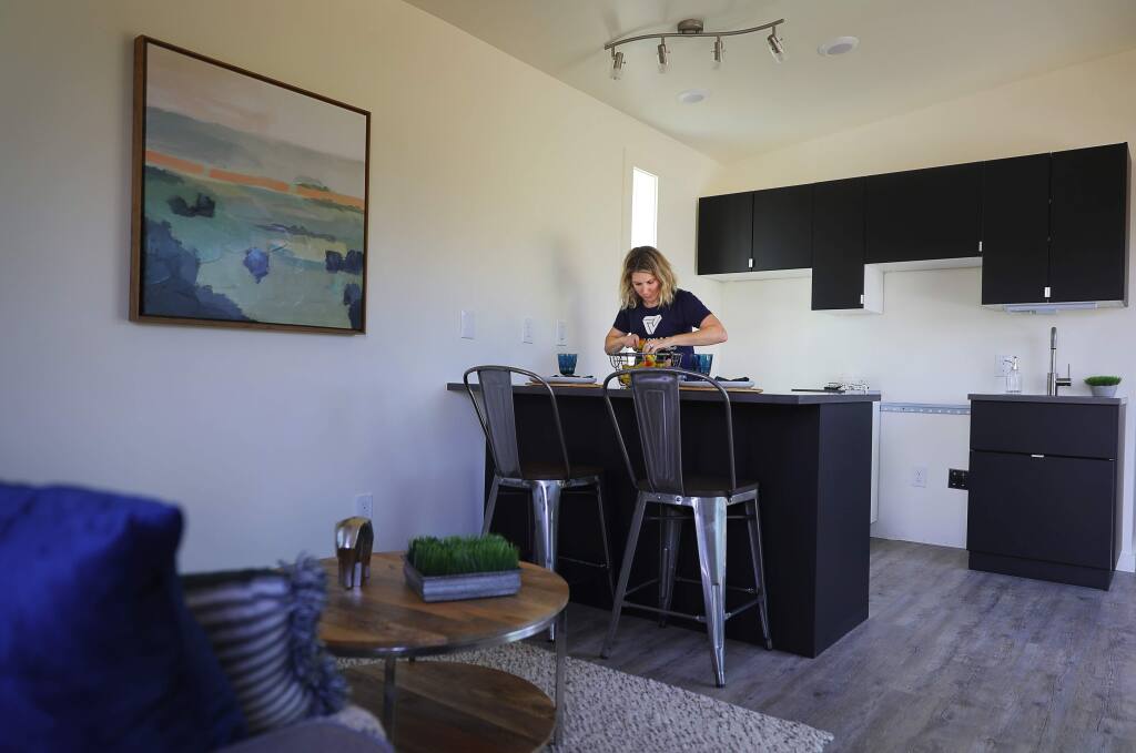 Shannon Howard-Bisordi, with Vanguard Properties, decorates the kitchen of a cottage for Homes for Sonoma, in Fulton on Wednesday, October 3, 2018. The goal of Homes for Sonoma is to create cost-effective neighborhoods for individuals and families displaced by the fires, and those being squeezed out of the rental housing market in Sonoma County.(Christopher Chung/ The Press Democrat)