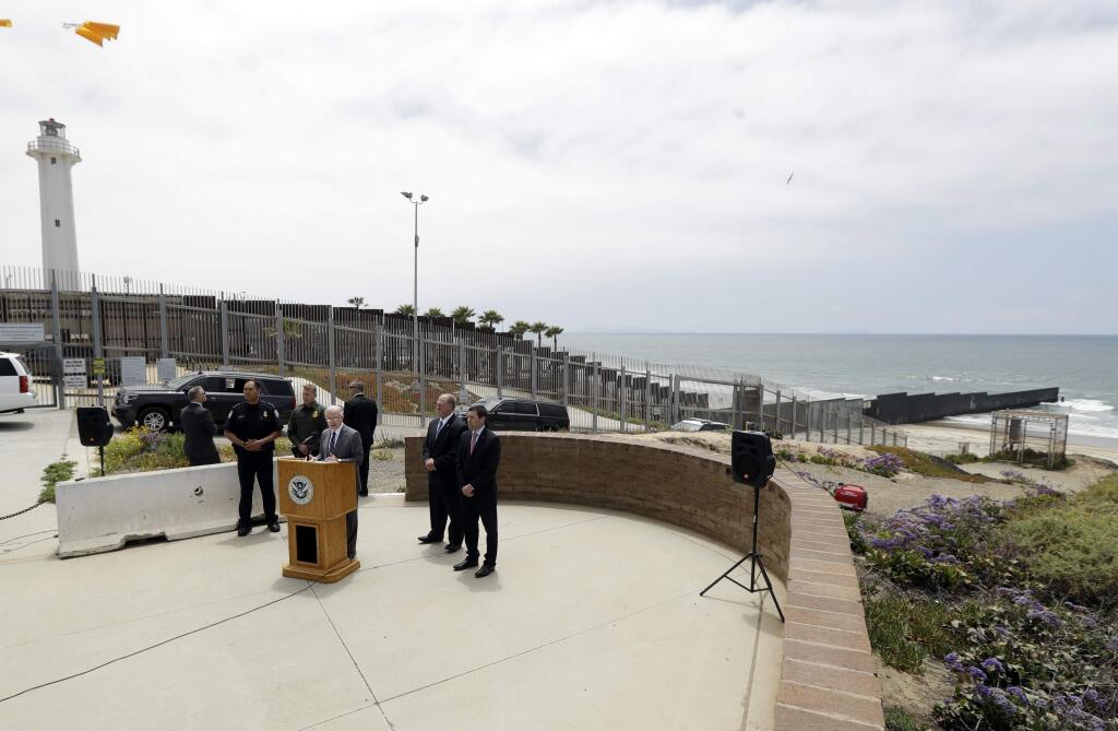 Attorney General Jeff Sessions, left at podium, speaks during a news conference near the border with Tijuana, Mexico, behind, Monday, May 7, 2018, in San Diego. Sessions discussed immigration enforcement during his Southern California visit Monday. (AP Photo/Gregory Bull)