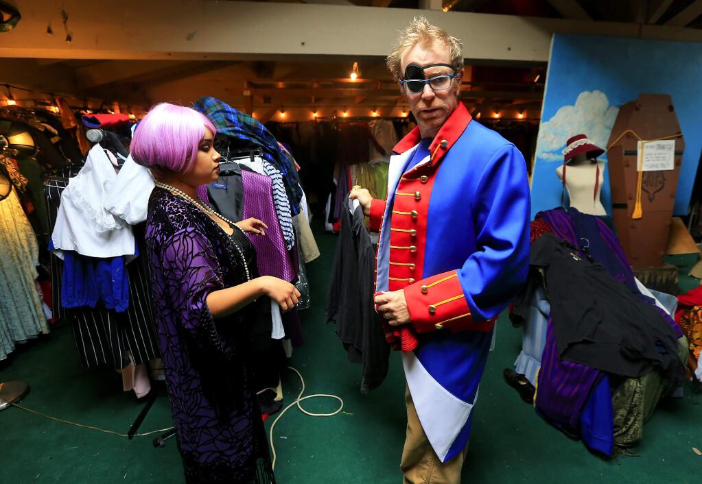 Iliana Sanchez, left, helps Ron Hill of Santa Rosa with the pirate costume he decided was perfect for Halloween after recent eye surgery left him with an eye patch at Disguise the Limit in Santa Rosa on Saturday, October 29, 2016. (John Burgess/The Press Democrat)