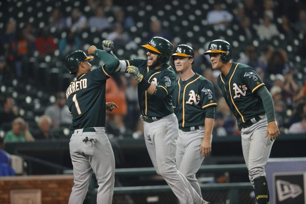 Oakland Athletics' Jed Lowrie, second from left, celebrates hitting a grand slam against the Detroit Tigers wth Franklin Barreto (1) as Chad Pinder and Joey Wendle watch in the eighth inning of a baseball game in Detroit, Tuesday, Sept. 19, 2017. (AP Photo/Paul Sancya)