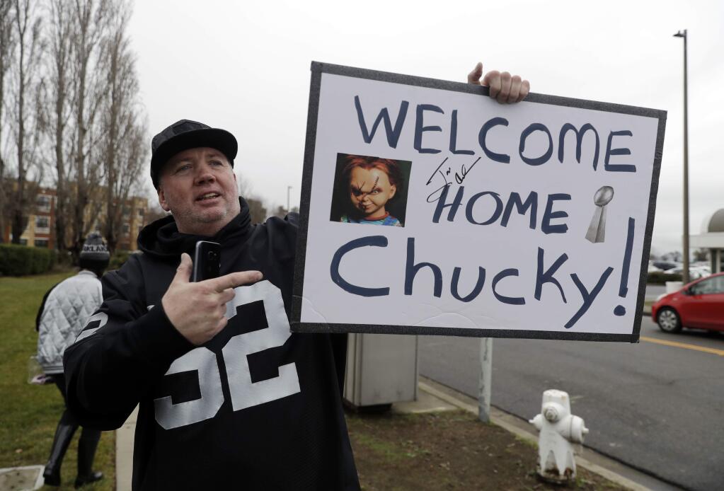 Oakland Raiders fan Gary Nankivel holds a sign welcoming the team's new head coach Jon Gruden before an NFL football press conference to announce Gruden's hiring Tuesday, Jan. 9, 2018, in Alameda, Calif. (AP Photo/Marcio Jose Sanchez)