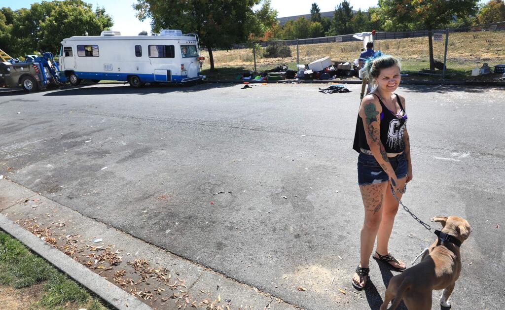 Crystal Dunigan with dog Tank, contemplates the next step as her motorhome is towed from Challenger Way, Wednesday, Sept. 19, 2018 in Santa Rosa. Dunigan, who went to high school in Healdsburg, was, along with others, able to remove her belongings from the vehicle. (Kent Porter / Press Democrat) 2018