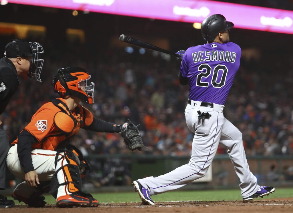 Colorado Rockies' Ian Desmond swings for an RBI double off San Francisco Giants' Derek Holland during the sixth inning Friday, May 18, 2018, in San Francisco. (AP Photo/Ben Margot)