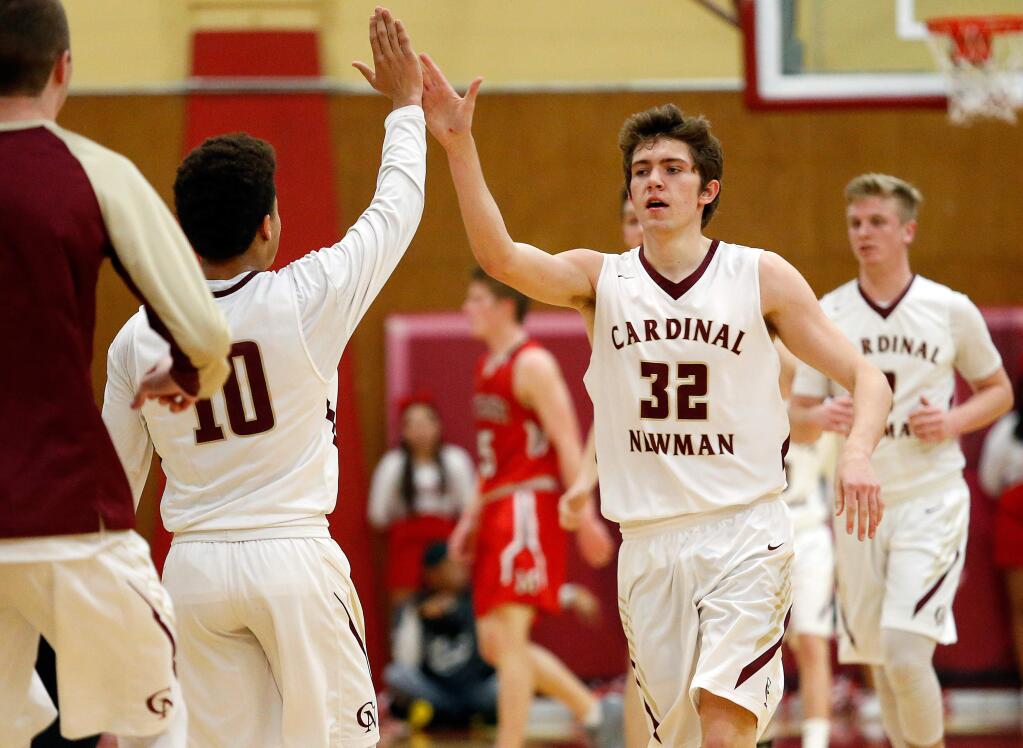 Cardinal Newman's Christian Hextrum (32), right, high-fives teammate Damian Wallace (10) after Hextrum stole the ball and scored during the first half of a boys varsity basketball game between Montgomery and Cardinal Newman high schools in Santa Rosa, California on Friday, January 13, 2017. (Alvin Jornada / The Press Democrat)