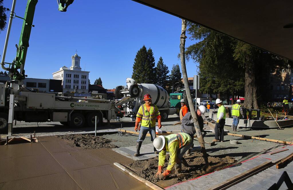 Construction workers put in the new sidewalk on the east side of Santa Rosa's Old Courthouse Square on Friday, December 30, 2016. (Christopher Chung/ The Press Democrat)