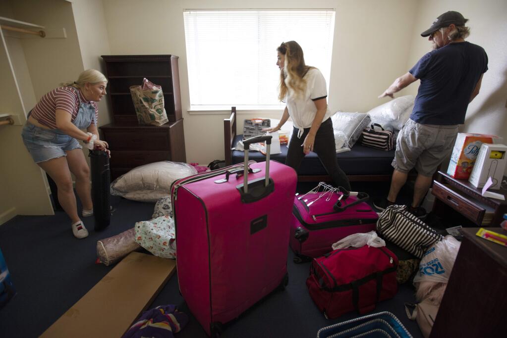 First year SSU student Matilda Prole, 10, left with her parents Patricia and Robert Prole of Pasadena, California all working on setting up Matilda's dorm room Saturday at Sonoma State University in Rohnert Park. August 18, 2018.(Photo: Erik Castro/for The Press Democrat)