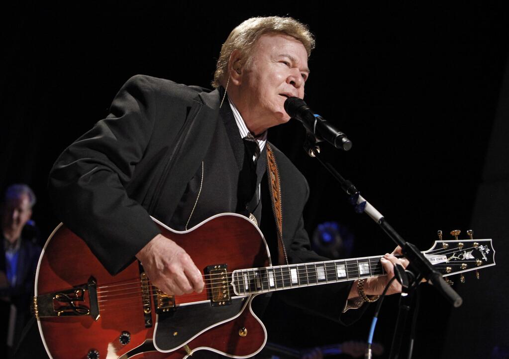 FILE - In this May 17, 2009, file photo, country music star Roy Clark performs after being inducted into the Country Music Hall of Fame in Nashville, Tenn. Clark, the guitar virtuoso and singer who headlined the cornpone TV show 'Hee Haw' for nearly a quarter century, died Thursday, Nov. 15, 2018, due to complications from pneumonia at home in Tulsa, Okla., publicist Jeremy Westby said. He was 85. (AP Photo/Mark Humphrey, File)