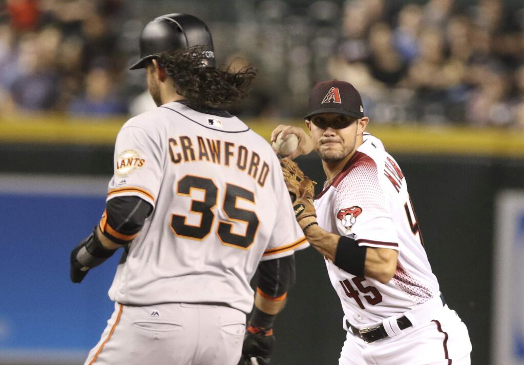 Arizona Diamondbacks's shortstop Kristopher Negron throws to first for a double play against the San Francisco Giants' Brandon Crawford during the second inning of a baseball game, Monday, Sept. 25, 2017 in Phoenix. (AP Photo/Darryl Webb)