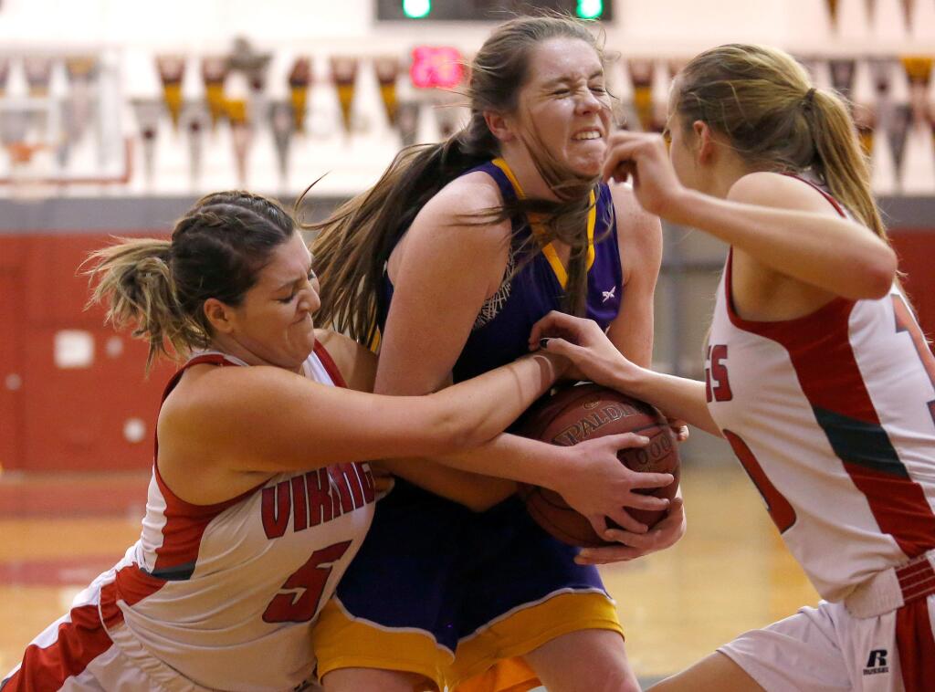 Ukiah's Kirstin Johnson (44), center, tries to wrestle a rebound away from Montgomery's Julia Watson (5), left, during the first half of a girls varsity basketball game between Ukiah and Montgomery high schools in Santa Rosa on Tuesday, January 24, 2017. (Alvin Jornada / The Press Democrat)