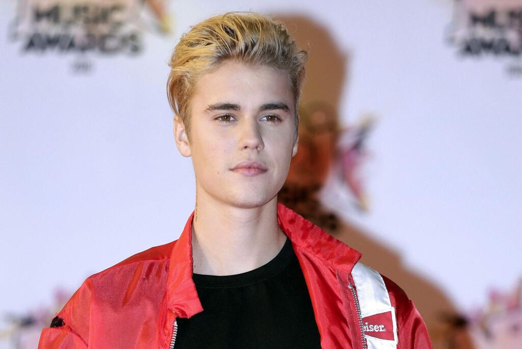 FILE - In this Nov. 7, 2015 file photo, Justin Bieber arrives at the Cannes festival palace in Cannes, southeastern France. Bieber's custom-built 2011 Ferrari 458 Italia is on the auction block. the car can be previewed in person in Scottsdale, Ariz., on Jan. 14 and 15, 2017. (AP Photo/Lionel Cironneau, File)